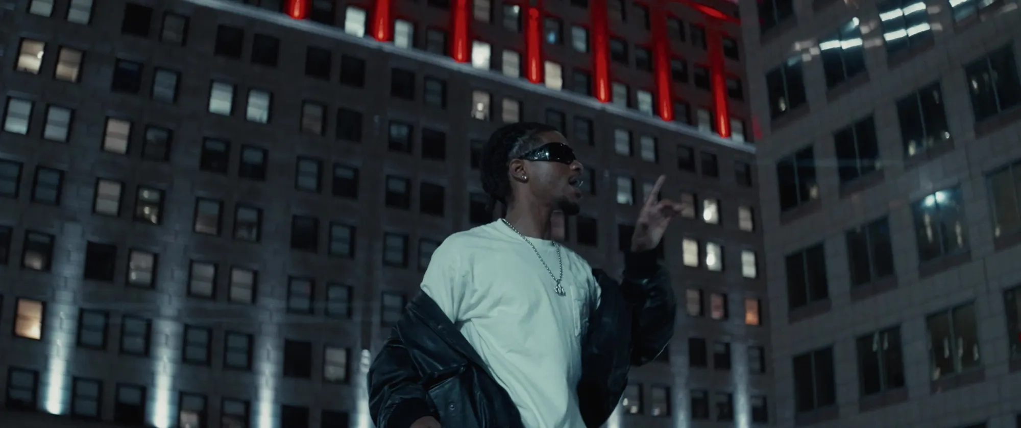 EliJah performing beneath red-lit columns in downtown Cleveland