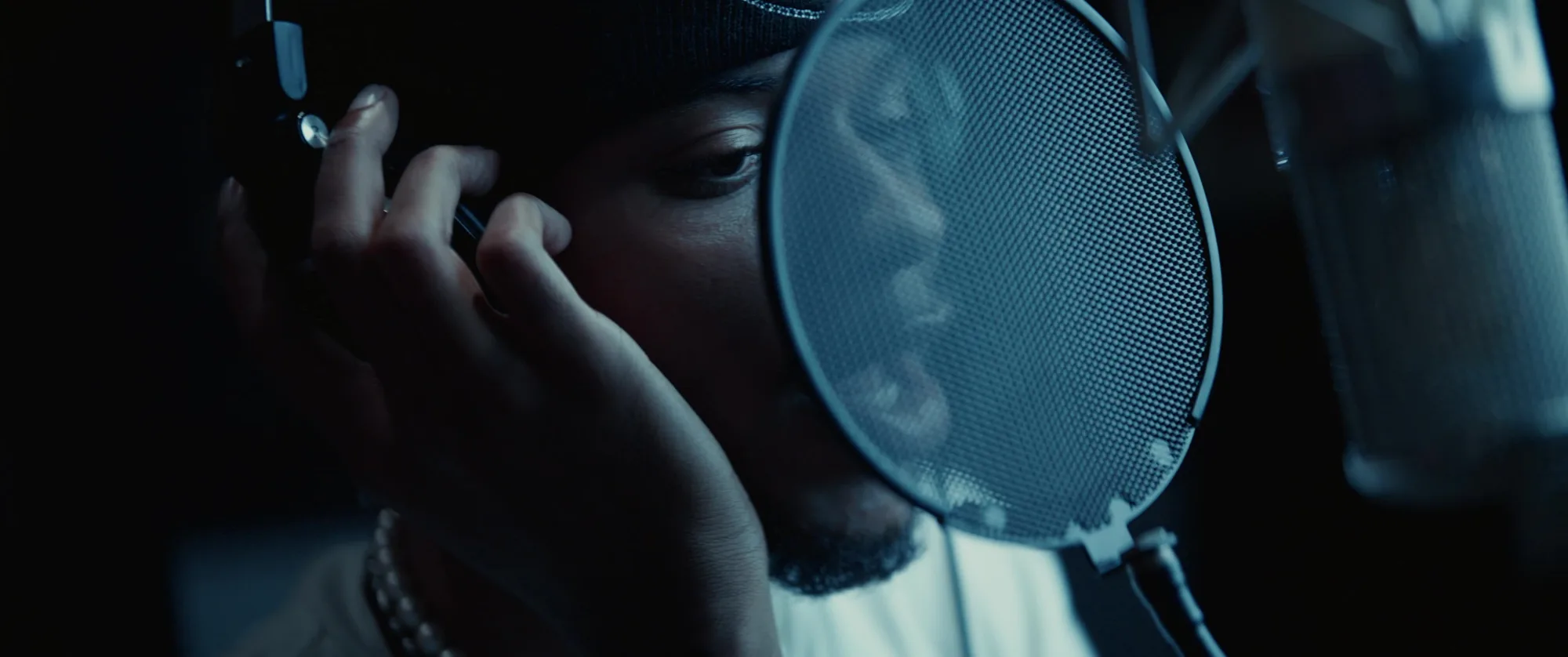 EliJah recording vocals behind a studio pop filter