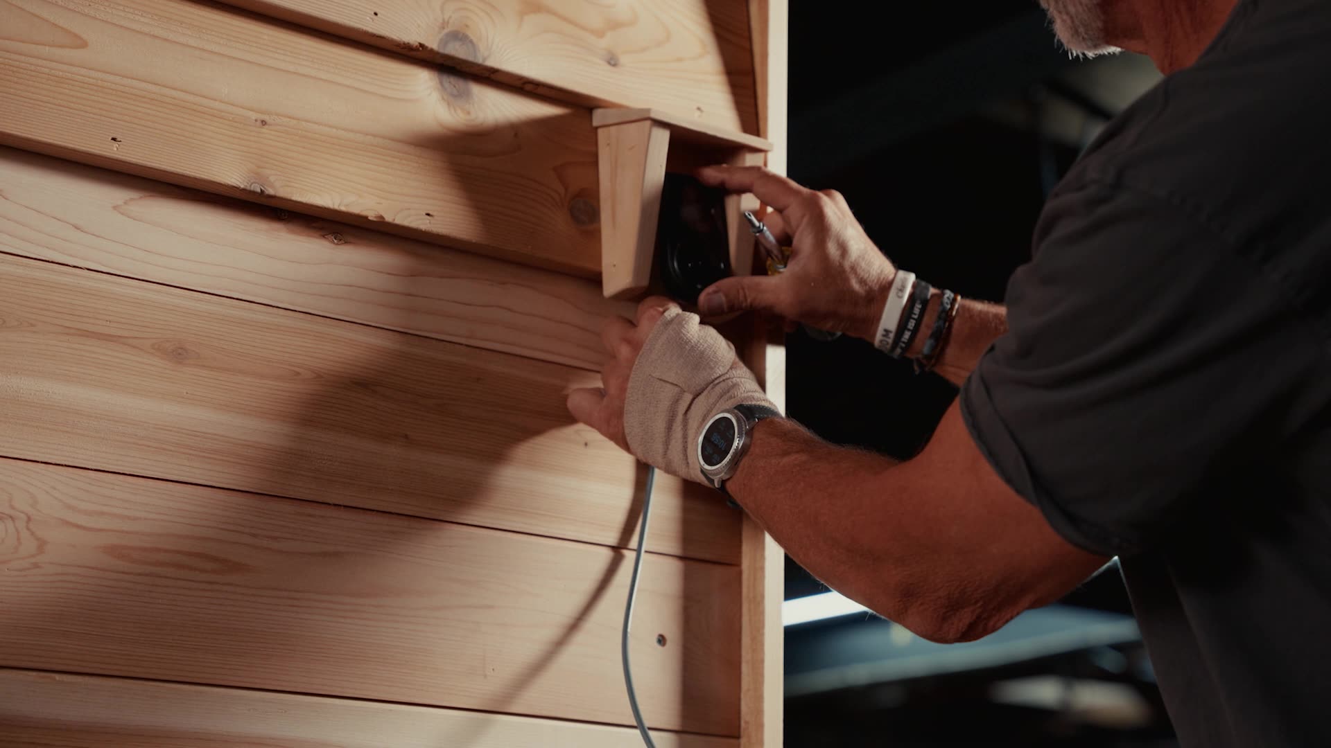 A hand adjusting a SISU sauna control