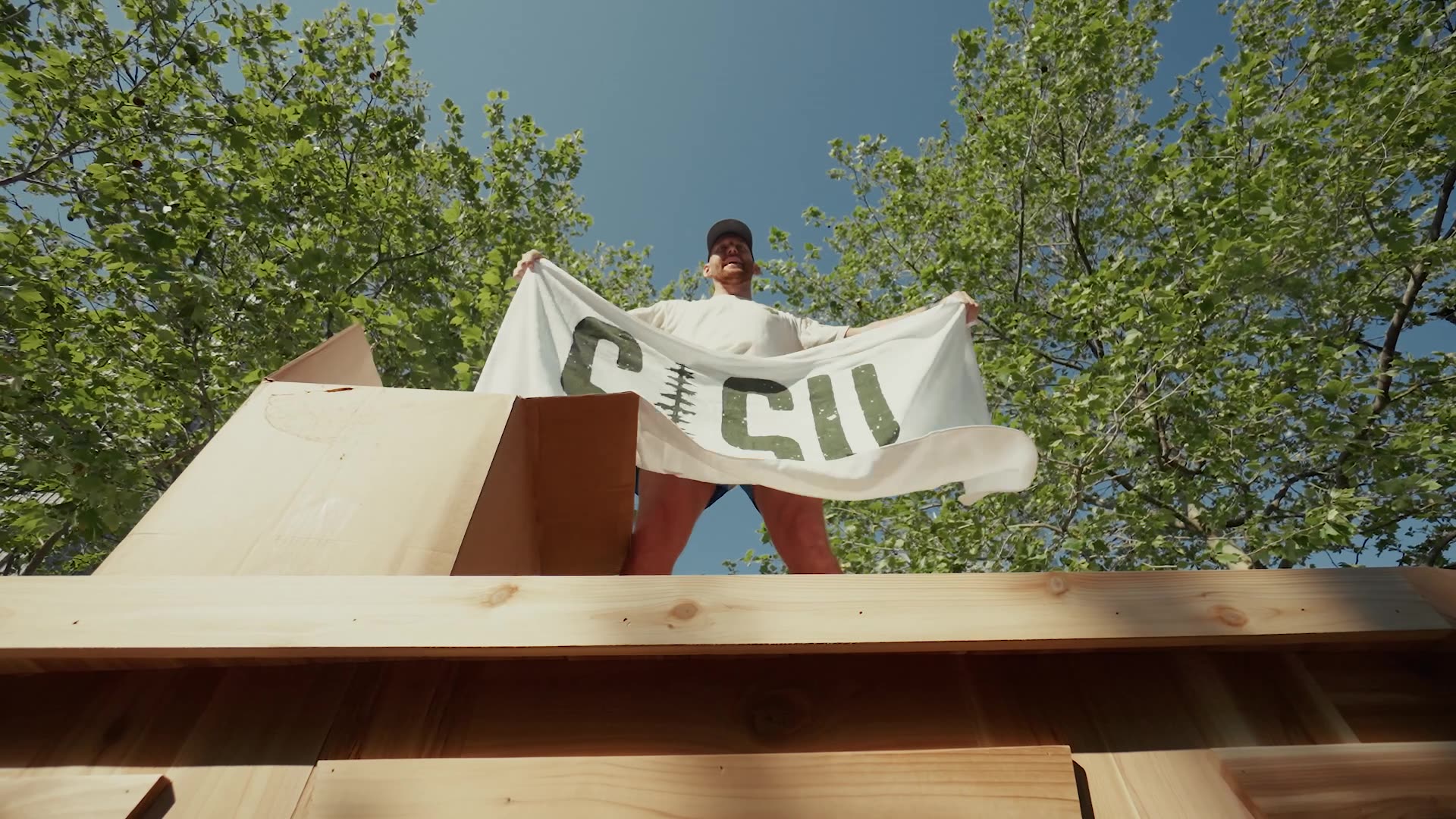 Pete Nelson II holding a SISU flag above a sauna